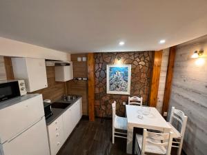 a kitchen with a table and chairs in a room at Apartmani Vila Vjerra in Žabljak