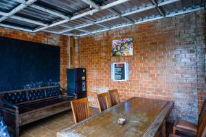 a dining room with a table and a brick wall at Urbanview Hotel Syariah Prambanan by RedDoorz in Yogyakarta
