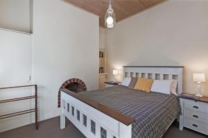 1 dormitorio con 1 cama y chimenea en Cottage on James circa 1855 en Port Fairy