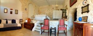 a bedroom with a bed and a table and chairs at Traditional seafront apartment in Symi