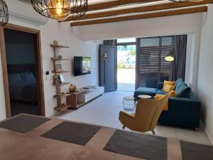 a living room with a blue couch and a chair at Courtyard Luxury Suites “ APOSTOLOS” in Pefki