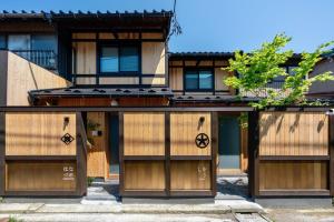 - un bâtiment avec des portes en bois devant dans l'établissement Hanatsume Machiya House, à Kanazawa