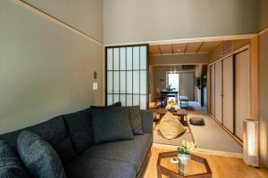 - un salon avec un canapé et une table dans l'établissement Hanatsume Machiya House, à Kanazawa