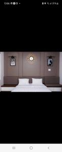 a bedroom with a large white bed with a mirror at Hotel The Quin in Hai Phong