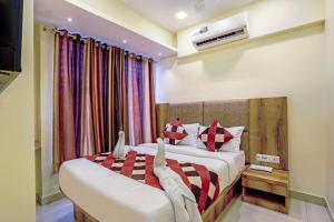 a hotel room with two beds and a television at BKC Dormitory Bandra East in Mumbai