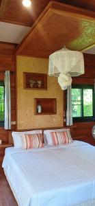 a bedroom with a large bed with white sheets at Suntisook Resort in Ko Yao Noi