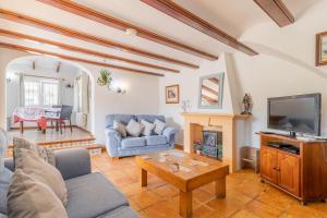 ein Wohnzimmer mit einem Sofa und einem TV in der Unterkunft Tranquil Restored Farmhouse in Benitatxell