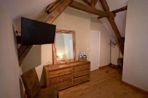 a living room with a flat screen tv on the wall at Le Clos Du Murier in Chassignelles