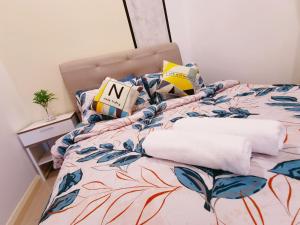 Legoland-HappyRainbow Suite at D'Pristine-8pax with Lakeview في نوساجايا: غرفة نوم مع سرير مع لحاف من الزهور