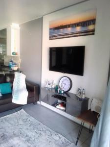 a living room with a couch and a tv on a wall at 42 Ramsgate palms in Margate