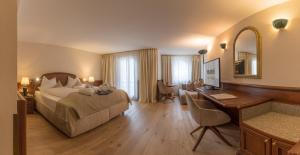 a hotel room with a bed and a desk and a desk at MANNI das Hotel in Mayrhofen