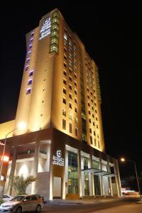 فندق دلال سيتي في الكويت: مبنى كبير فيه سيارة متوقفة أمامه