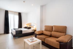 ein Wohnzimmer mit einer Couch und einem Bett in der Unterkunft Plaza de la Luz Cádiz in Cádiz + 26 Fotos