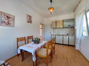 a kitchen with a table and chairs and a kitchen with a table and a kitchen at Villa Guesthouse Luna in Pečurice