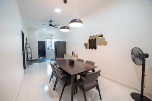 - une salle à manger avec une table, des chaises et un ventilateur dans l'établissement HILMERA Guesthouse, à Kuantan