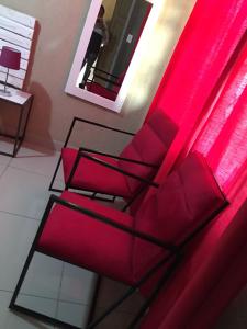 une chaise rouge dans une pièce avec un miroir dans l'établissement Asante’s Guest House, à Calcutta