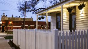 una cerca blanca frente a una casa en Heritage Cottage Daylesford, en Daylesford