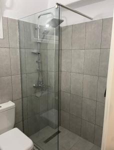 a bathroom with a glass shower with a toilet at 415 Guest House in Xanthi