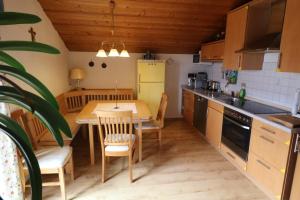 a kitchen with a wooden table and a table and chairs at Ferienwohnungen Anna Geißinger in Mauth