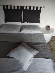 a bed with two pillows on top of it at Villa Elia Ios in Ios Chora