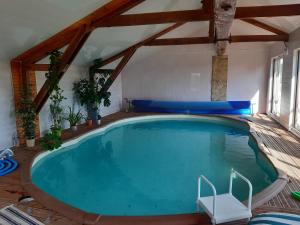 uma grande piscina num quarto com pisos e vigas de madeira em le Trésor de Gabaret em Burosse-Mendousse