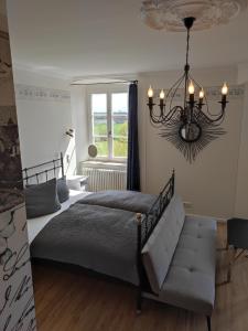 a bedroom with a bed and a chandelier at Schloss Kalteneck in Schwenningen