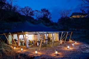 a tent with lights in front of it at night at Serengeti Pioneer Camp in Mugumu