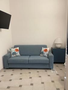 1 sofá azul con 2 almohadas en la sala de estar en betty house, en Campomarino
