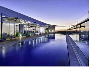 a large building with a swimming pool at night at The Menlyn Main Residents Trilogy in Pretoria