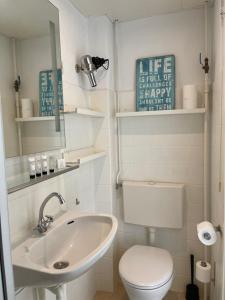 uma casa de banho branca com um WC e um lavatório em Top View em Zandvoort