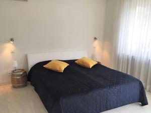 a bedroom with a large bed with two yellow pillows at Alice Holiday Apartment in Locarno