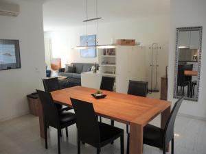 ein Esszimmer mit einem Holztisch und schwarzen Stühlen in der Unterkunft Alice Holiday Apartment in Locarno