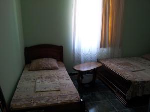 a room with two beds and a table and a window at Hotel Luka, near Church in Ureki