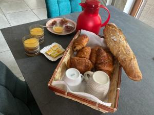 a basket of bread and croissants on a table at Les Berouds in Salaise-sur-Sanne
