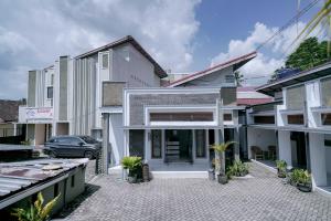 a house with a car parked in front of it at Urbanview Hotel Syariah Ratu Kuring Gisting by RedDoorz in Banjarnegeri
