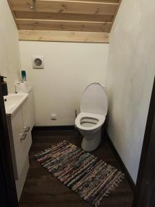 a bathroom with a toilet and a rug at Angerja in Kuru +8 photos