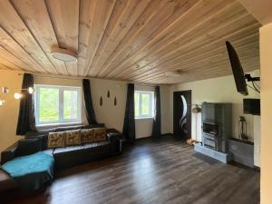 a living room with a couch and a wooden ceiling at Angerja in Kuru
