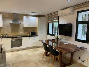 een keuken met een houten tafel met stoelen en een televisie bij PUERTO BANUS Apartamento LOLA in Marbella