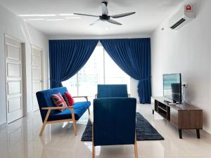 sala de estar con sillas azules y ventilador de techo en Merlene Suites at Mansion One Formerly know as Mansion One Suites en George Town