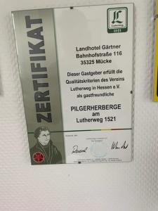 a sign on a wall with a picture of a man at Landhotel Restaurant Gärtner in Mücke