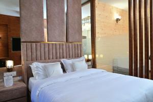 - un grand lit avec des oreillers blancs dans une chambre dans l'établissement The Royale Suites - HOME STAY, à Solan