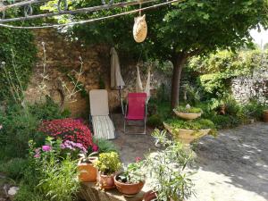 un jardín con mesa, sillas y flores en Mas d'Antan, en Saint-Paul-les-Fonts