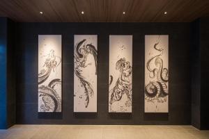 a wall with four different drawings on it at Via Inn Prime Kyotoeki Hachijoguchi in Kyoto