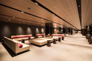 eine Lobby mit Sofas und Tischen in einem Gebäude in der Unterkunft Via Inn Prime Kyotoeki Hachijoguchi in Kyoto