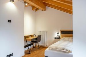 une chambre avec un lit et un bureau dans l'établissement Apart Dolomites, à Castello-Molina di Fiemme 10 autres photos