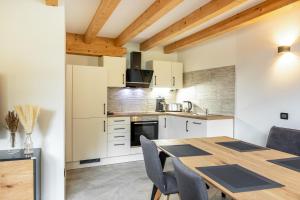 a kitchen with a wooden table and chairs at Apart Dolomites in Castello di Fiemme