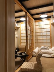 a room with a chair and a bed in it at 台甕茶室青年旅館 Tai-Wong Tatami Room Hostel in Tainan