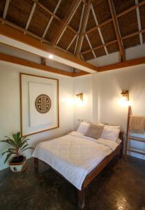 a bedroom with a bed with a plant in it at The Living Room Siargao in General Luna