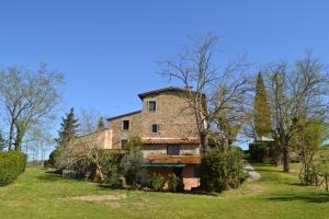 una vieja casa de piedra en un campo con árboles en Terre di Melazzano - Le Case di Patrizia en Greve in Chianti