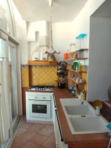cocina con fogones blancos y fregadero en Casa di Grazia, en Isquia
